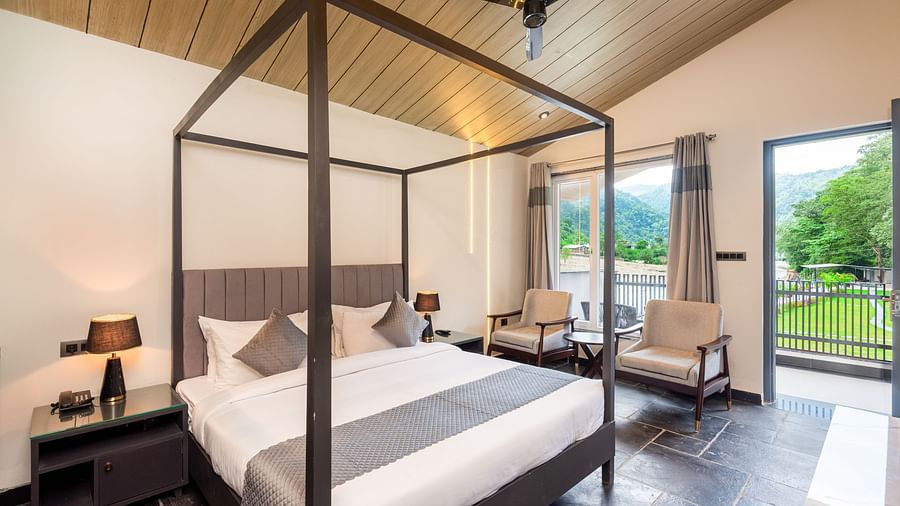 Luxury cottage at DLS Divine River Resort and Spa featuring a bed, chairs and a private balcony 